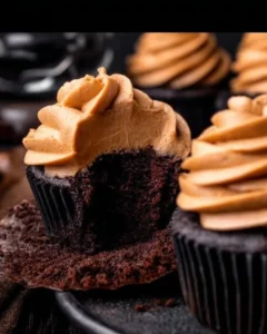 Freshly baked chocolate pumpkin cupcakes with creamy frosting and pumpkin decorations