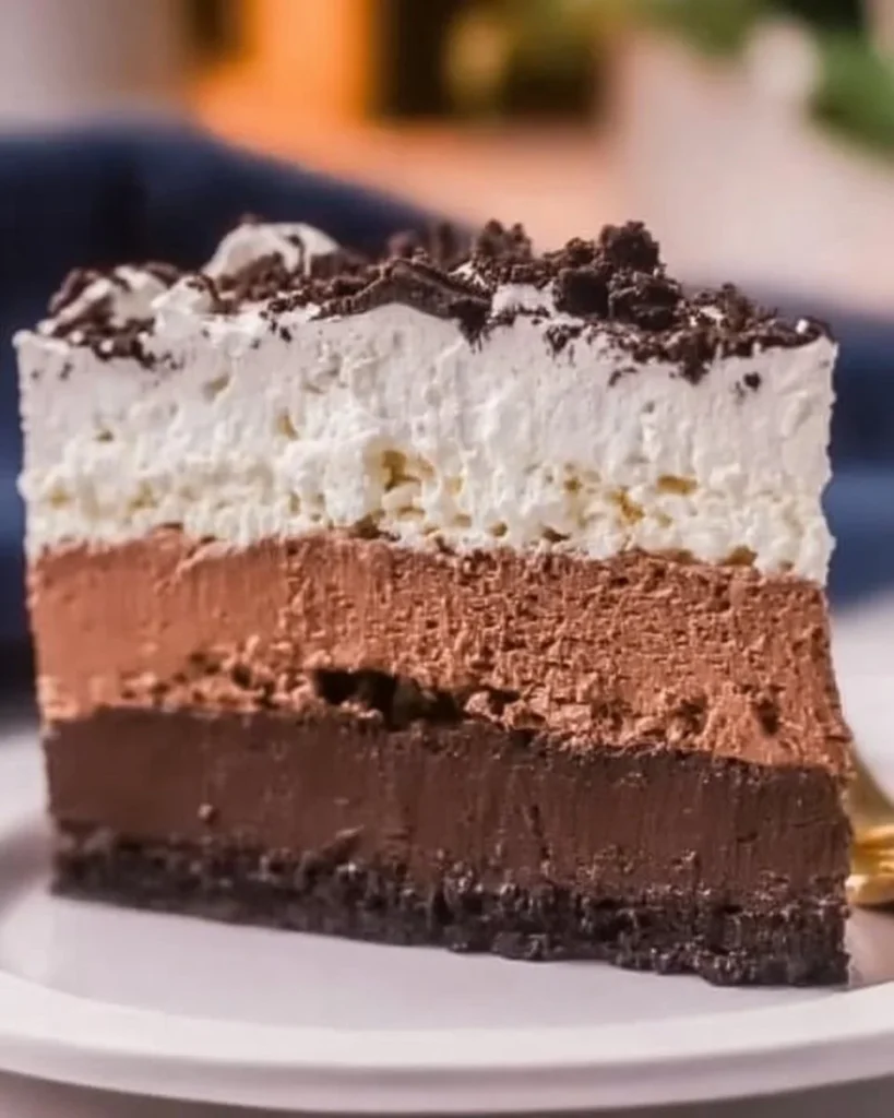 Delicious Oreo Mousse Cake topped with crushed Oreos and chocolate drizzle