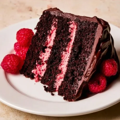 Delicious Chocolate Raspberry Cake topped with fresh raspberries and chocolate ganache.