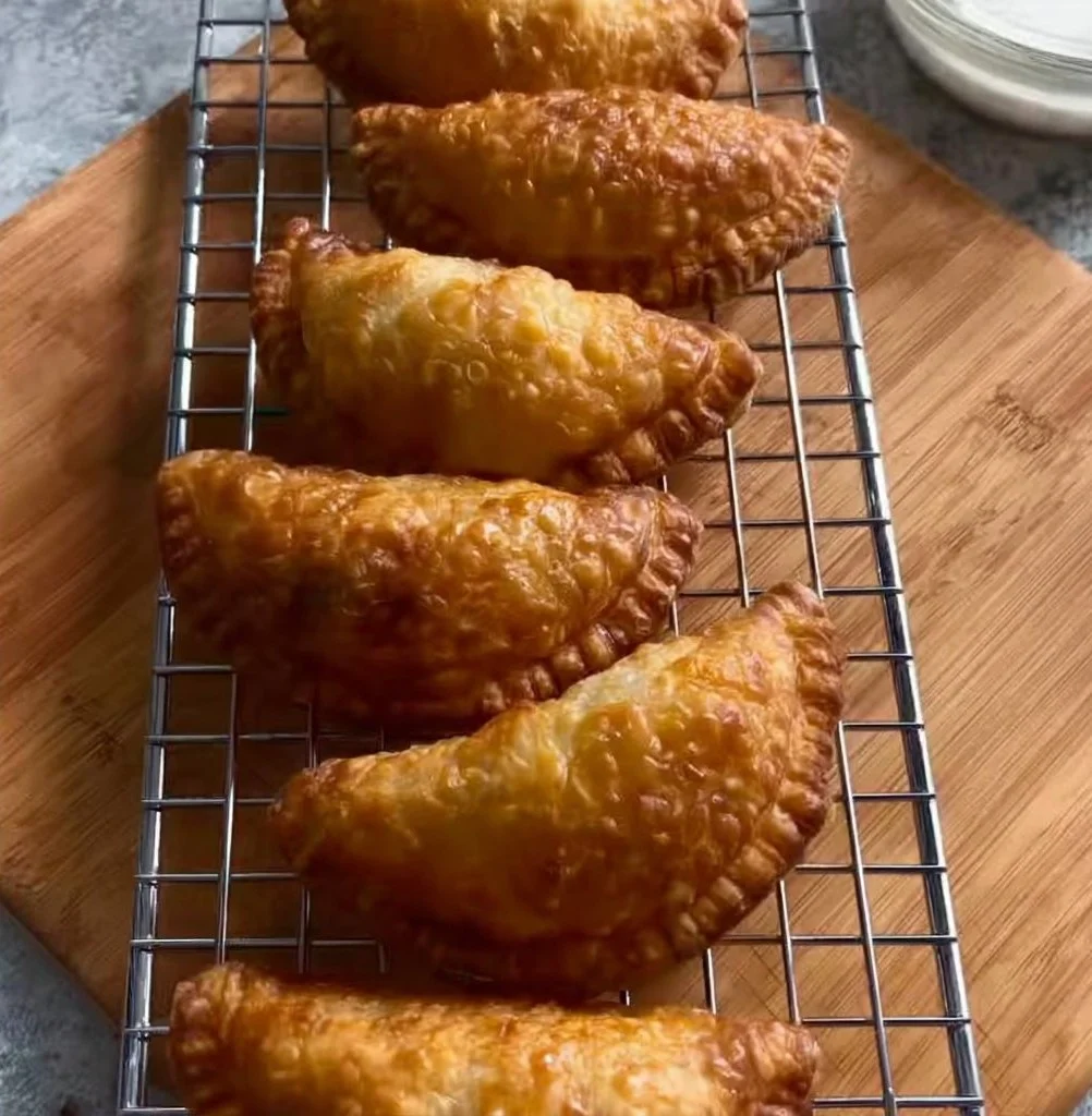Crispy beef pastries served on a plate with dipping sauce