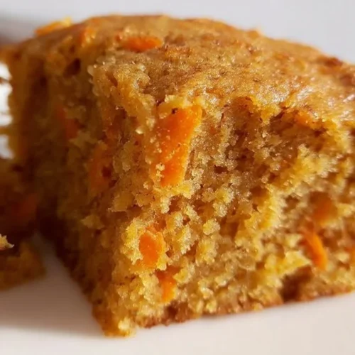 Slice of flourless oatmeal carrot cake on a plate with fork