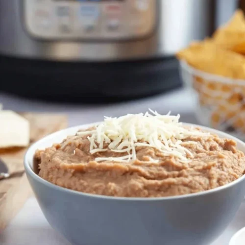 Bowl of creamy Instant Pot refried beans topped with cilantro