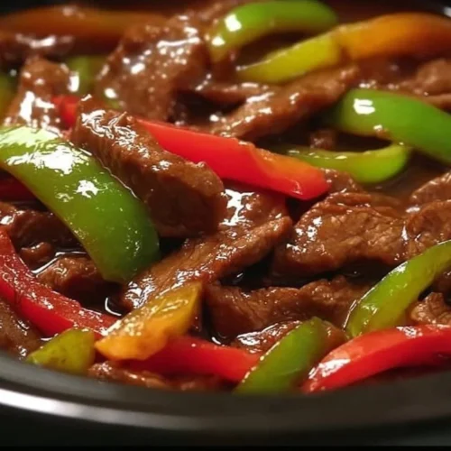 Tender crock pot pepper steak served with vegetables and rice