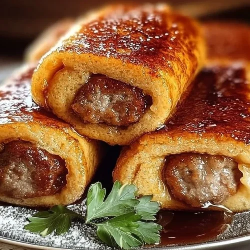 Sausage French Toast Roll-Ups ready to serve with syrup and berries