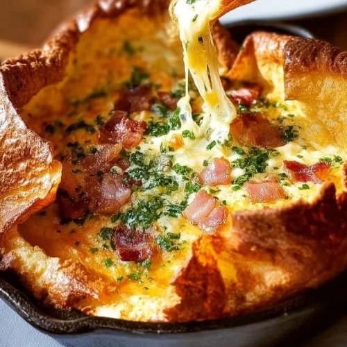 Savory Cheddar Turkey Bacon Dutch Baby topped with crispy turkey bacon and melted cheddar cheese