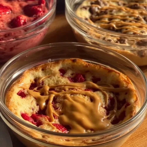 Fluffy baked protein pancake bowl topped with fresh berries and syrup.