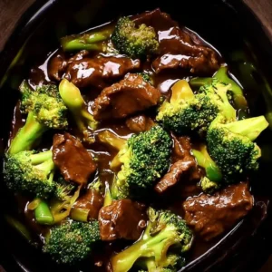 Tender crock pot beef and broccoli served on a plate with vegetables.