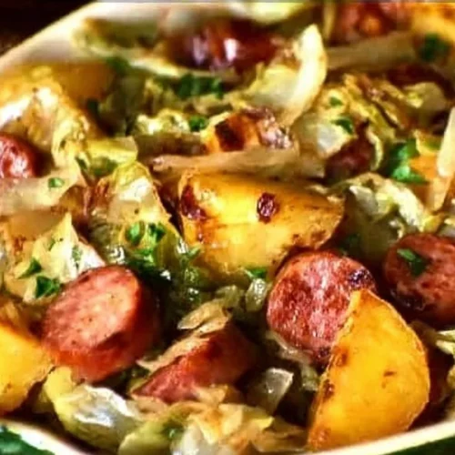 Braised cabbage with potatoes and smoked sausages served in a bowl.