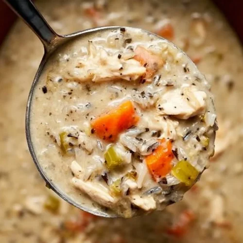 Creamy chicken wild rice soup in a crockpot garnished with herbs