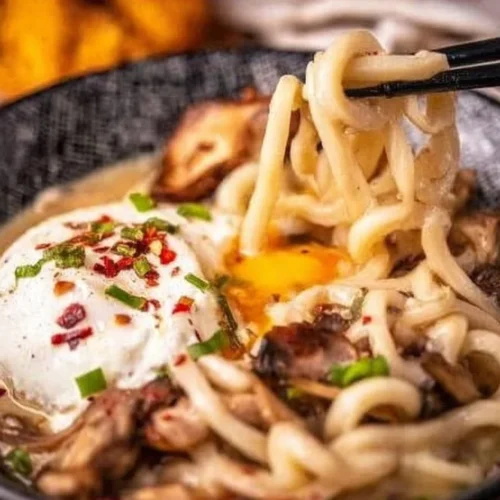 Bowl of creamy miso udon soup with vegetables and noodles