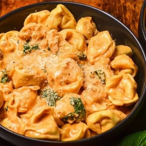 Delicious CrockPot Chicken Tortellini served in a bowl with fresh herbs