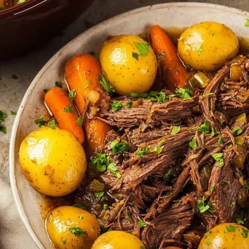 Delicious easy crockpot chuck roast recipe with vegetables cooking in a slow cooker.