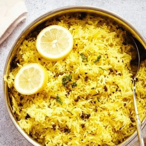 Greek Lemon Rice garnished with fresh herbs in a bowl.