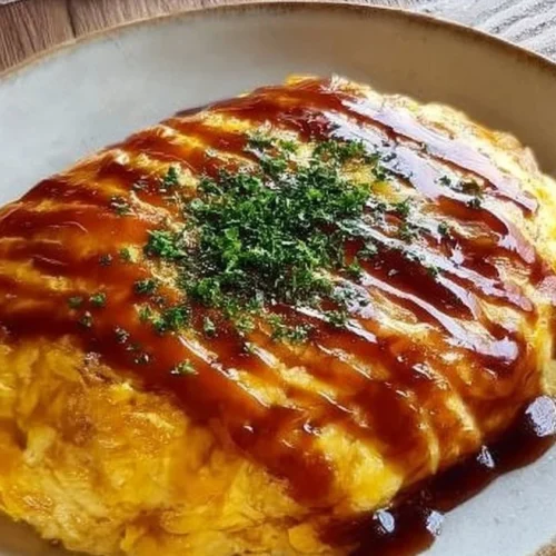 Japanese fried rice omelette topped with fresh herbs and served on a plate