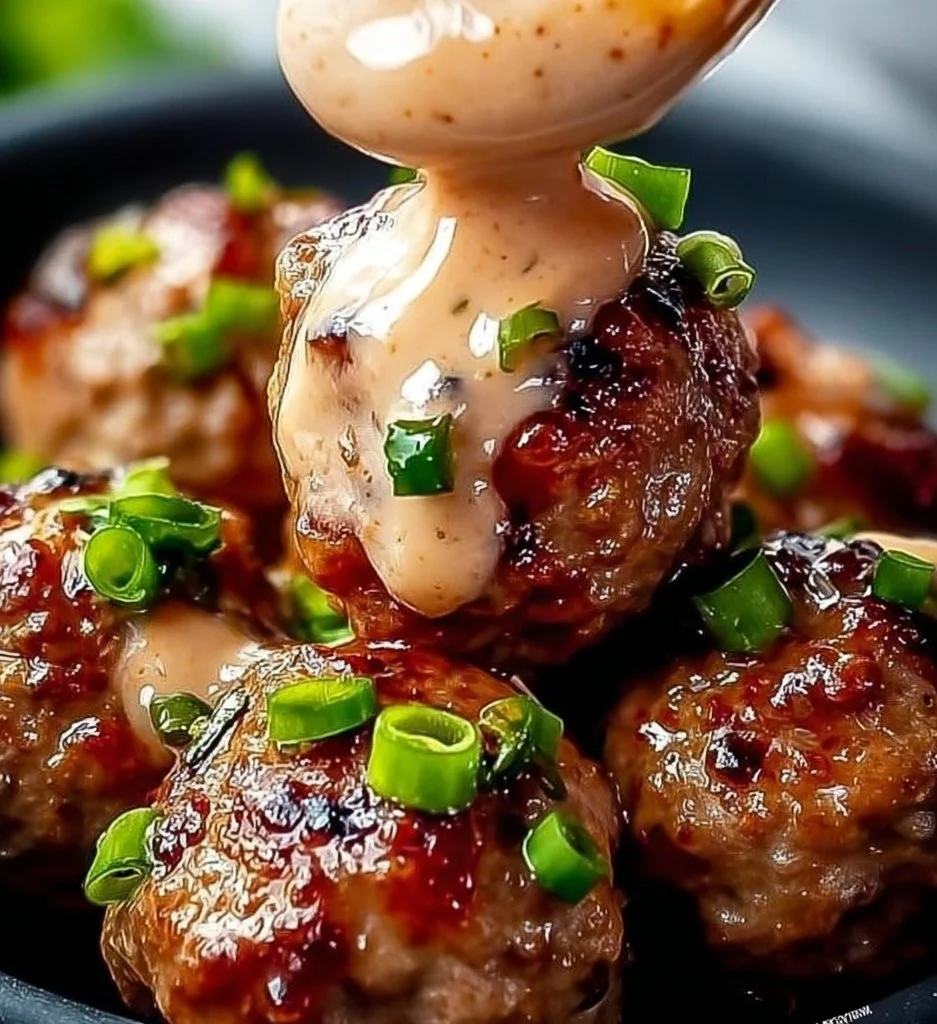 Korean BBQ Meatballs served with a spicy mayo dip on a plate.
