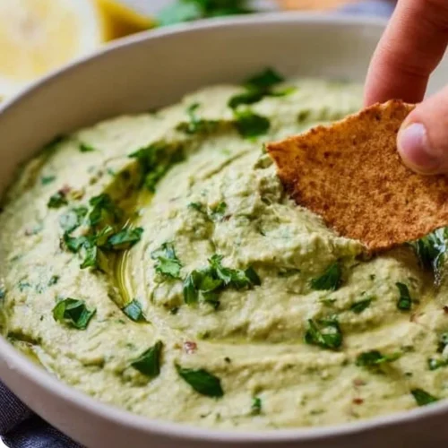 Delicious white bean dip served in a bowl with fresh veggies and crackers