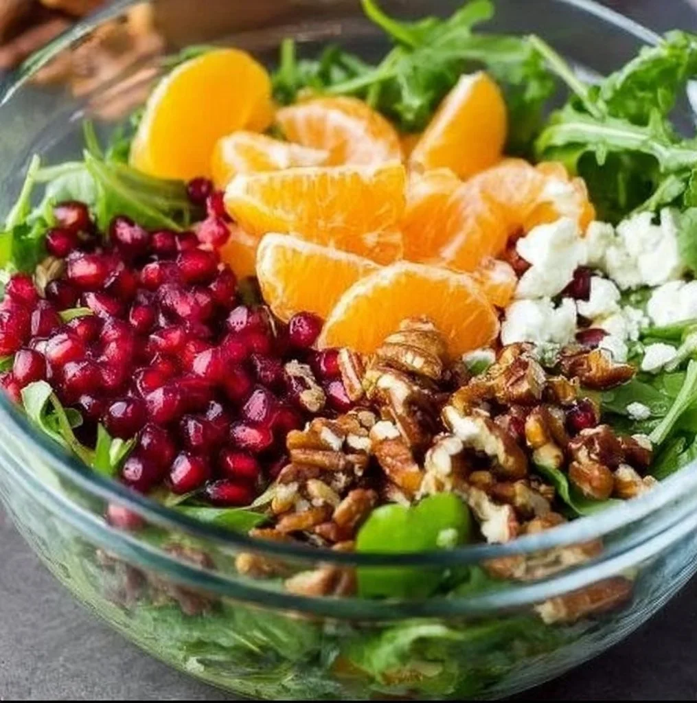A colorful winter salad featuring seasonal greens, fruits, and nuts.