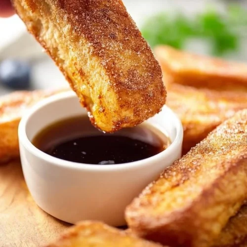 Crispy Air Fryer French toast sticks served with syrup and berries