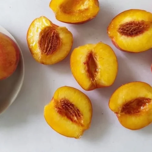 Air fryer grilled peaches served with ice cream and mint leaves