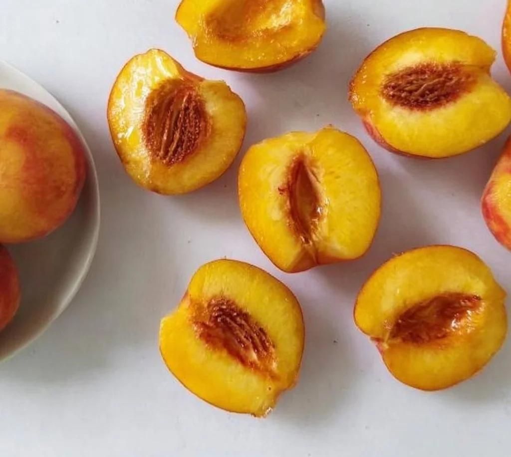 Air fryer grilled peaches served with ice cream and mint leaves