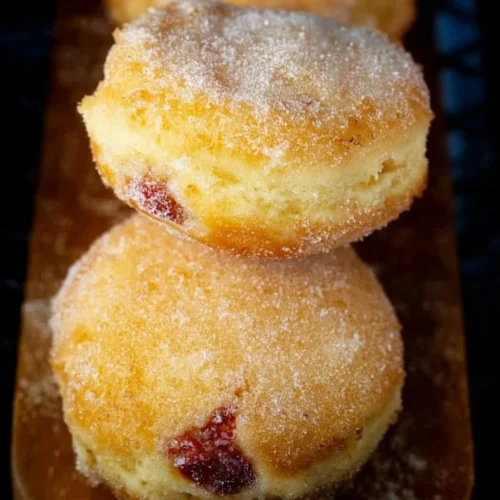 Air fryer jelly donuts with powdered sugar and jelly filling