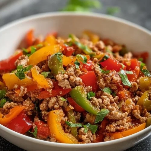 Sautéed ground turkey with colorful bell peppers in a skillet.