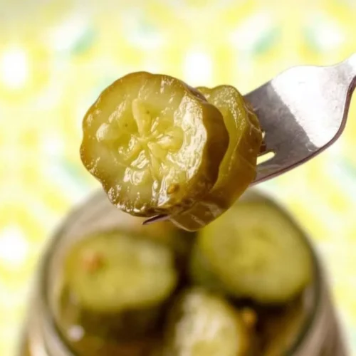 Homemade horseradish pickles served in a jar with spices and fresh vegetables