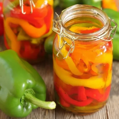 Jars of homemade pickled sweet peppers on a kitchen counter