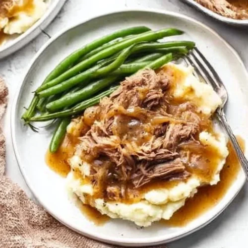 Instant Pot French Onion Pot Roast served with onions and herbs on a plate