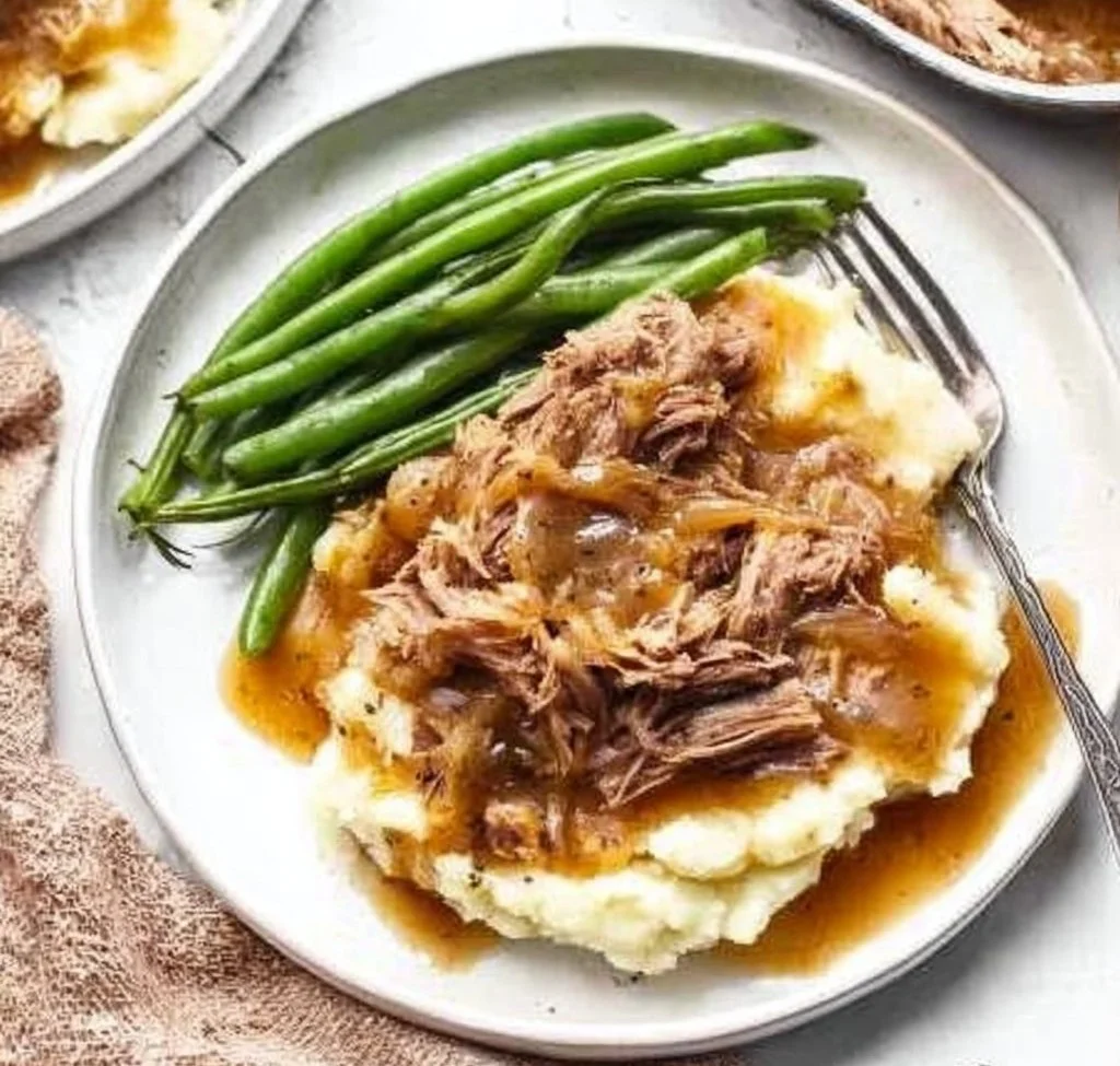 Instant Pot French Onion Pot Roast served with onions and herbs on a plate