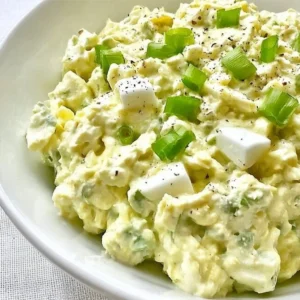 Keto avocado egg salad in a bowl garnished with herbs.