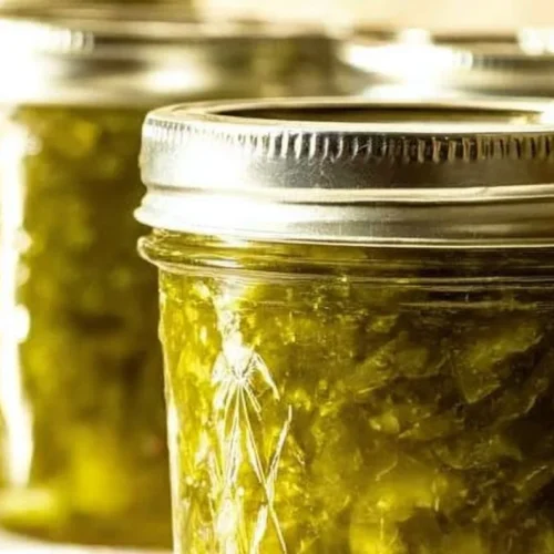 Homemade simple dill pickle relish in a jar with fresh cucumbers and spices
