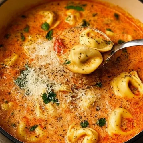 Bowl of simple Tomato Tortellini Soup garnished with fresh basil.