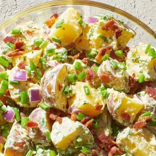 Creamy steakhouse potato salad served in a bowl with herbs and spices