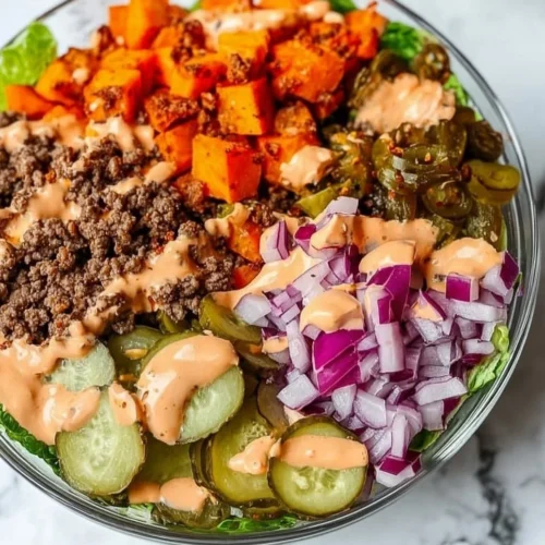 A vibrant sweet potato burger bowl topped with fresh vegetables and herbs