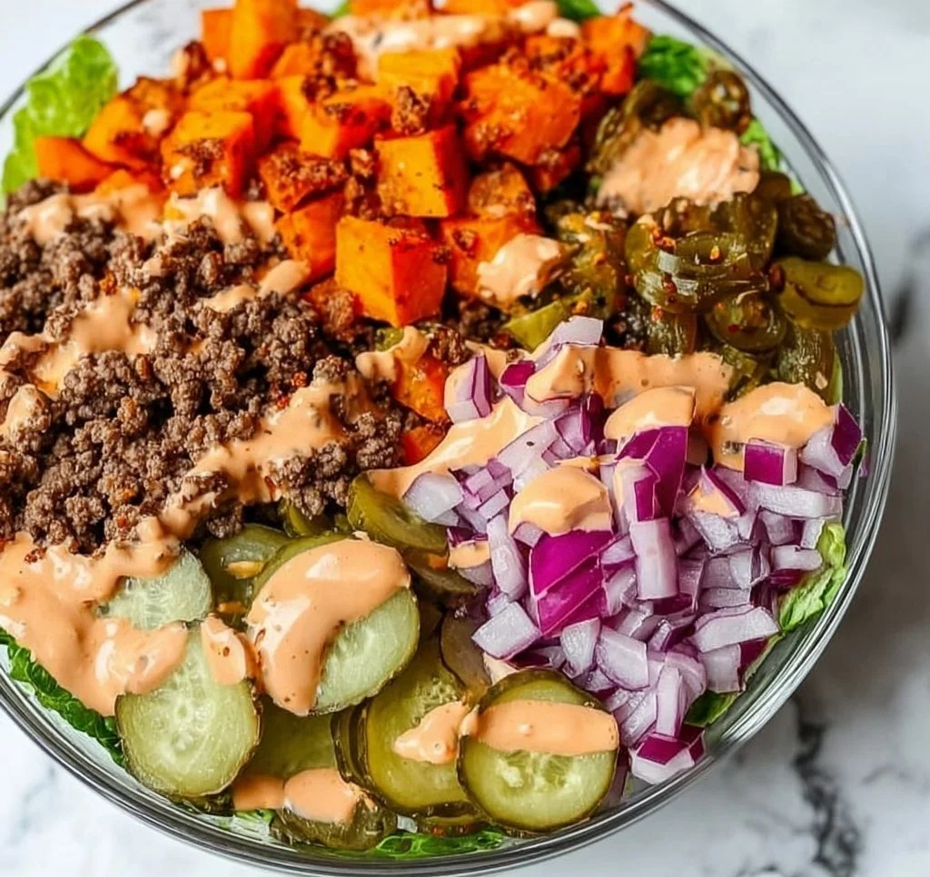 A vibrant sweet potato burger bowl topped with fresh vegetables and herbs