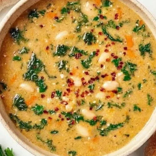 Bowl of Tuscan White Bean Soup garnished with herbs and crusty bread
