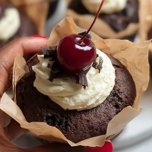 Delicious Black Forest Muffin topped with cherries and cream, showcasing decadent chocolate