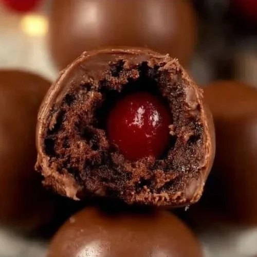 Chocolate cherry brownie bombs stacked on a plate, topped with cherry slices