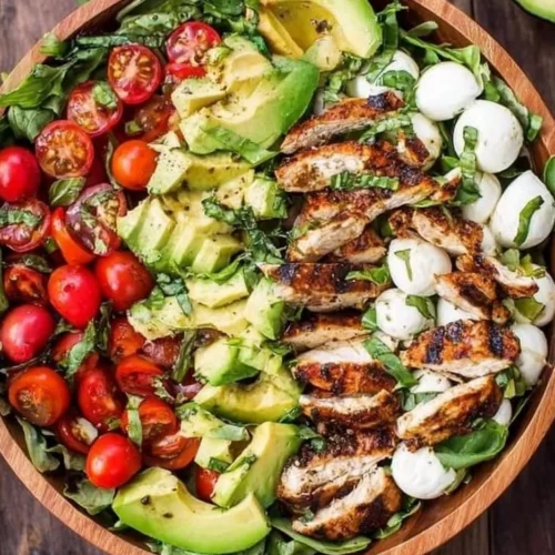 Colorful grilled chicken salad with fresh vegetables and dressing