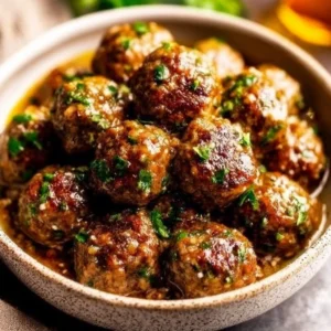 Plate of Keto Garlic Butter Meatballs with herbs and garlic sauce