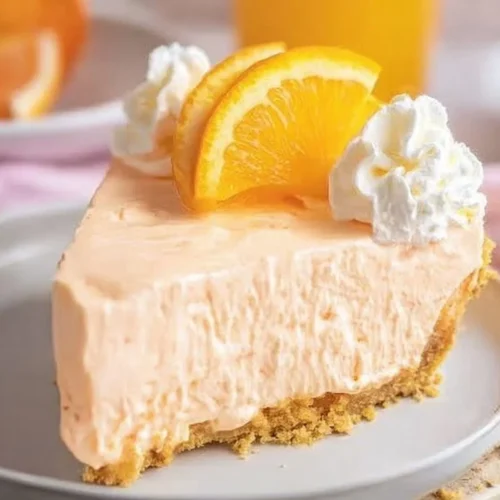 Delicious Orange Jello Creamsicle Pie topped with whipped cream and orange slices