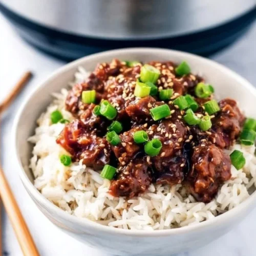 Slow Cooker Mongolian Beef served on a plate with rice and vegetables